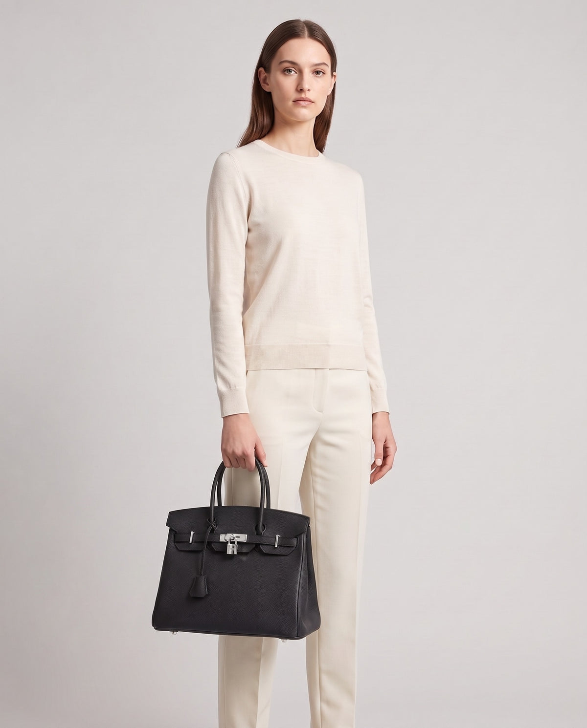 Lock Medium leather top-handle bag in Onyx – model holding it, full length
