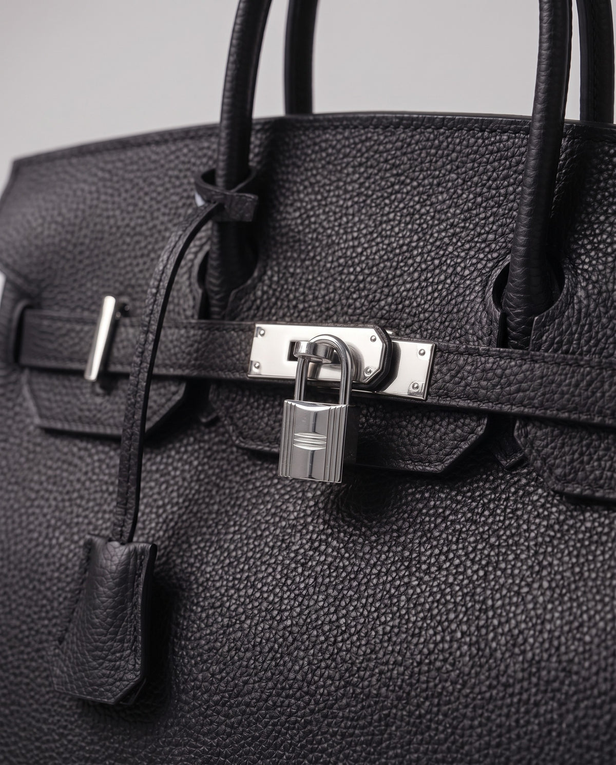 Lock Medium leather top-handle bag in Onyx – close-up of the silver turn-lock and padlock