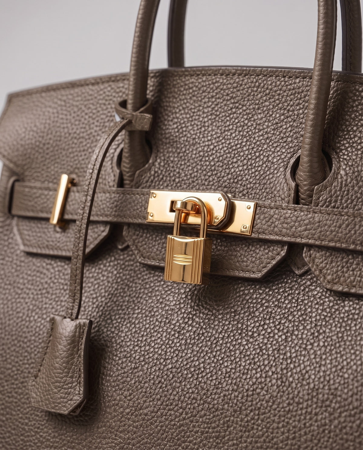 Lock Medium leather top-handle bag in Taupe – close-up of the gold turn-lock and padlock