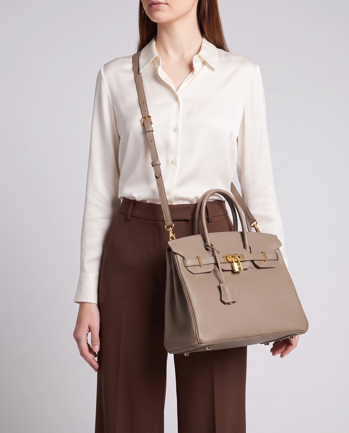 Lock Medium leather top-handle bag in Taupe – model wearing it crossbody on the detachable shoulder strap