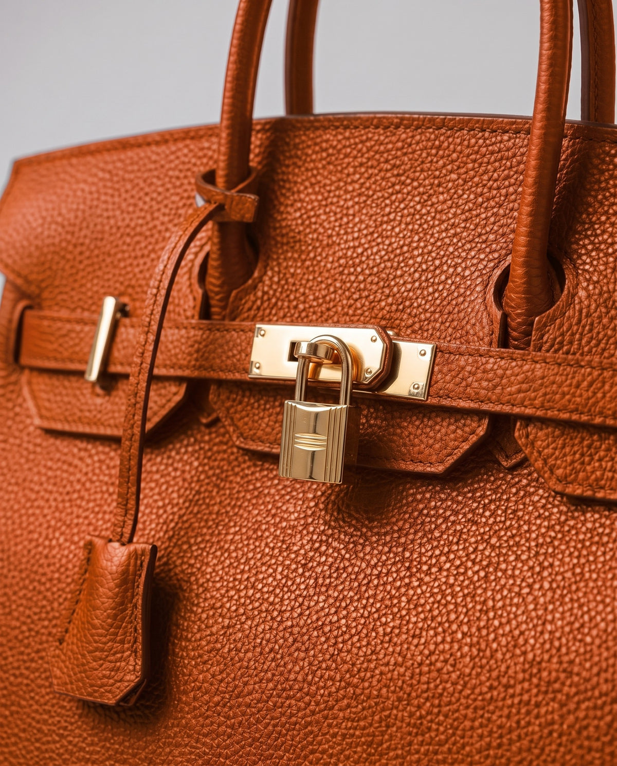 Lock Medium leather top-handle bag in Terracotta – close-up of the gold turn-lock and padlock