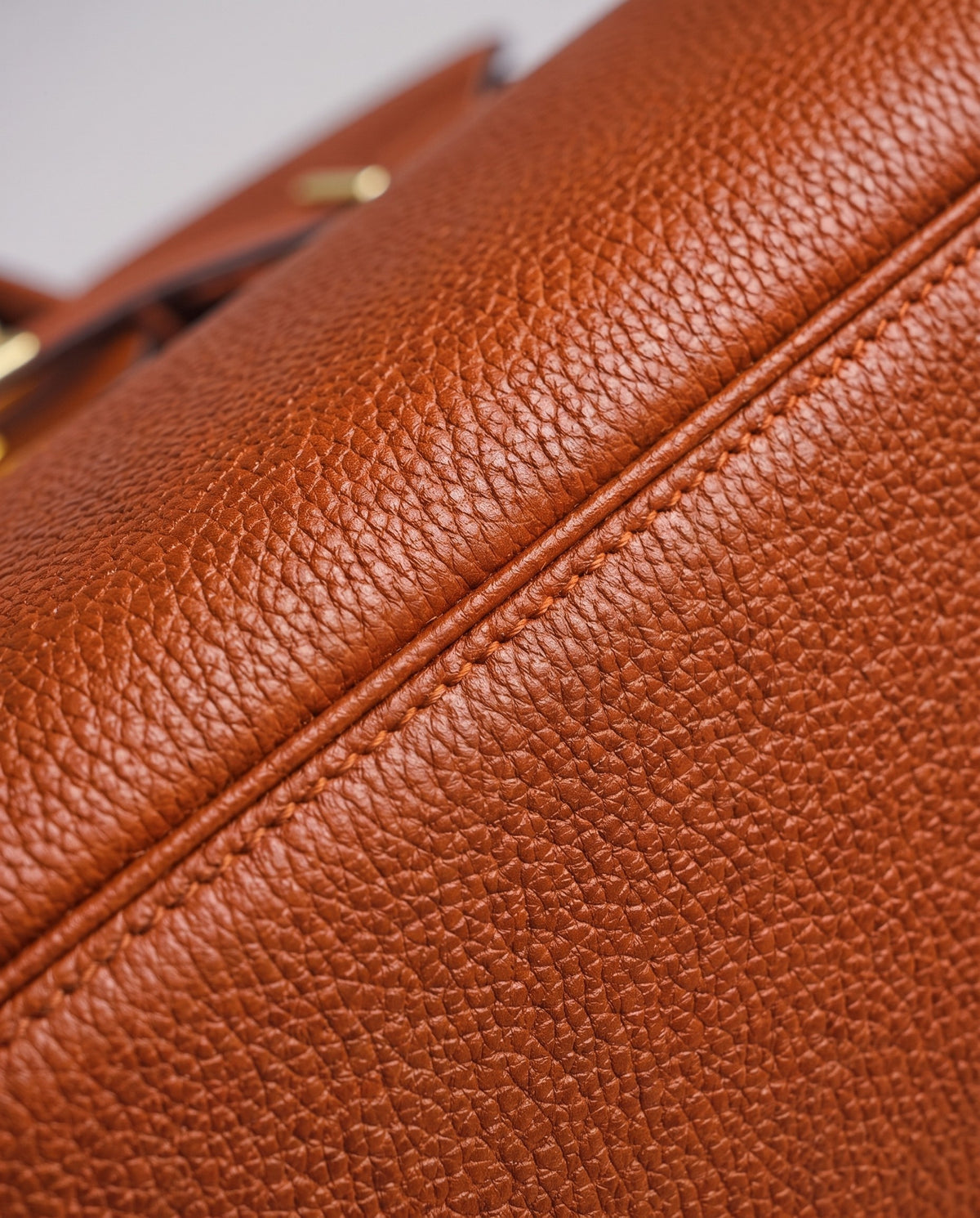 Lock Medium leather top-handle bag in Terracotta – close-up of the pebbled leather and stitching