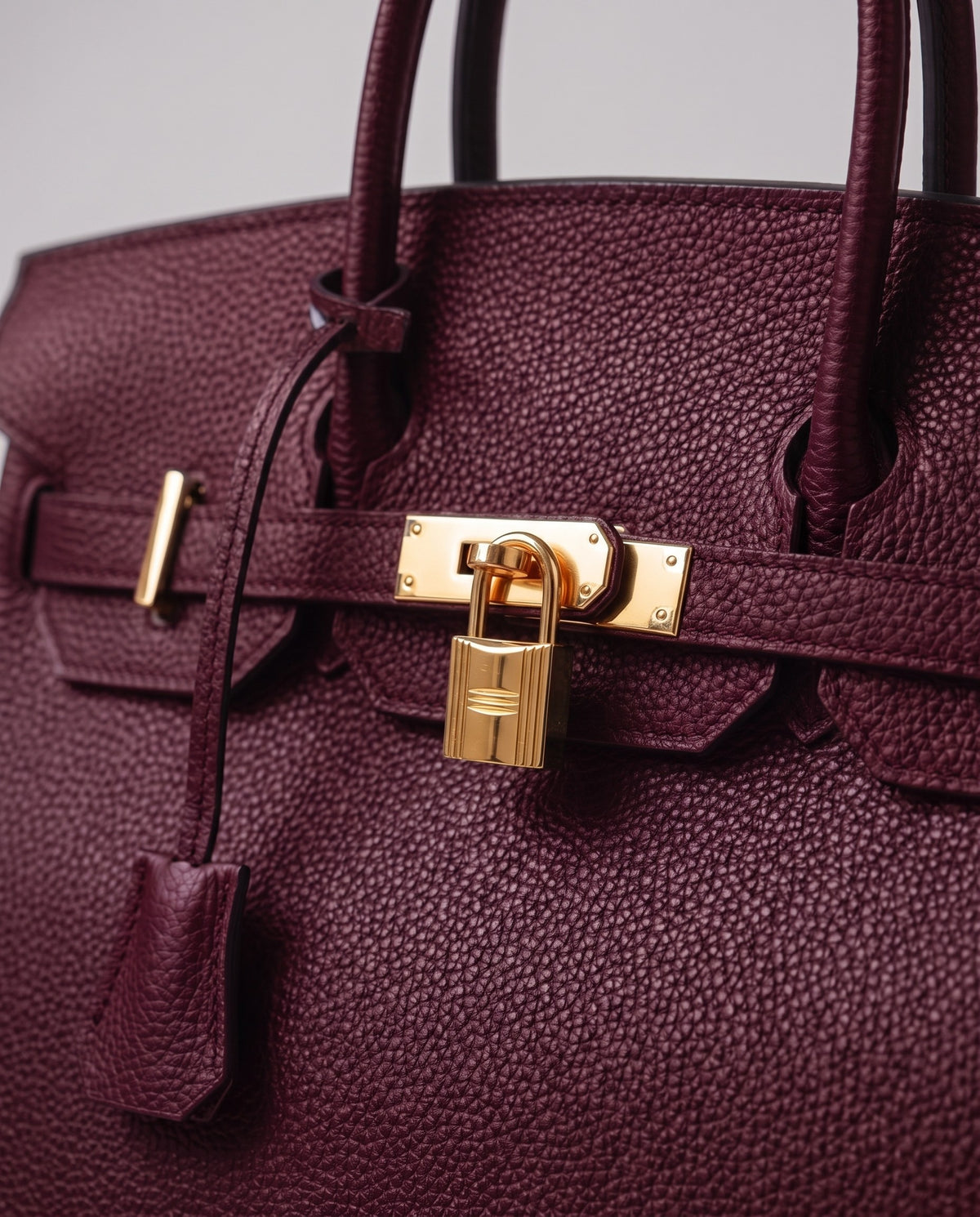 Lock Small leather top-handle bag in Bordeaux – close-up of the gold turn-lock and padlock