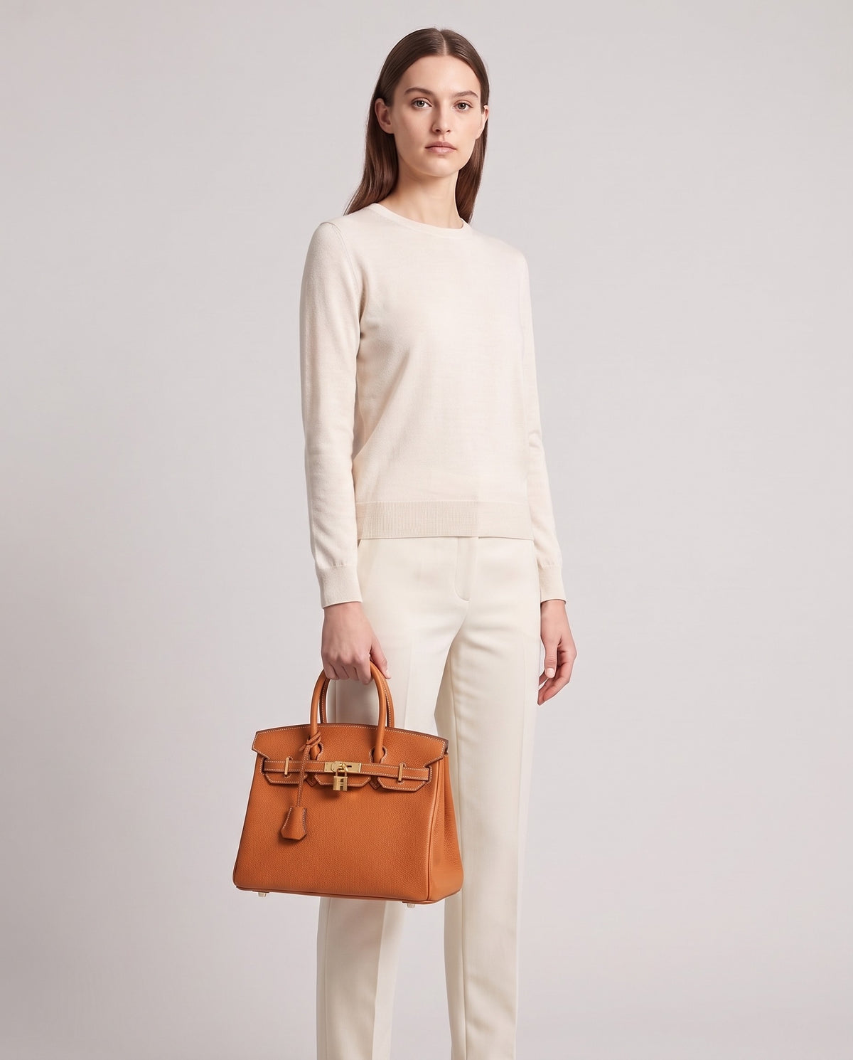 Lock Small leather top-handle bag in Caramel – model holding it, full length