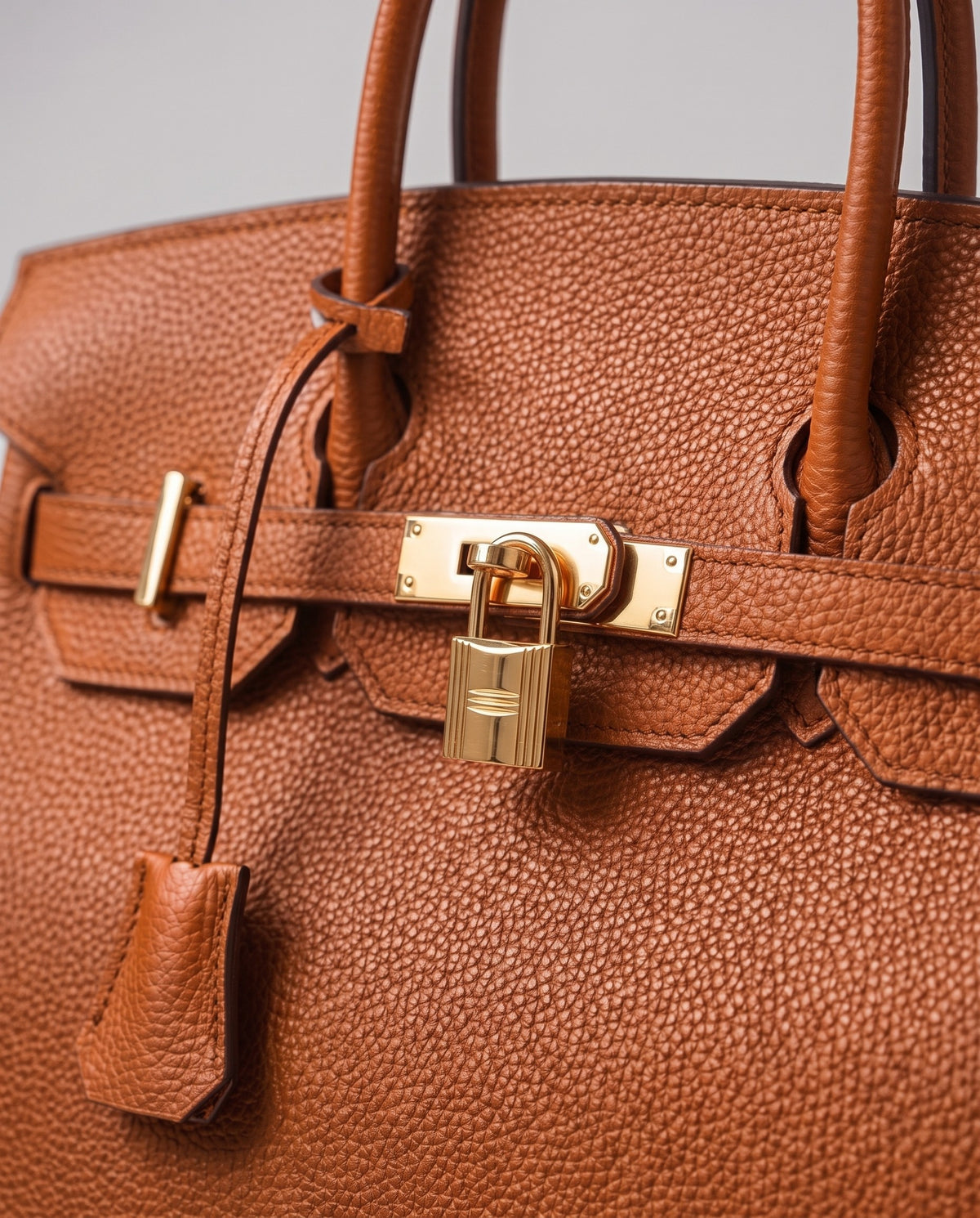 Lock Small leather top-handle bag in Caramel – close-up of the gold turn-lock and padlock
