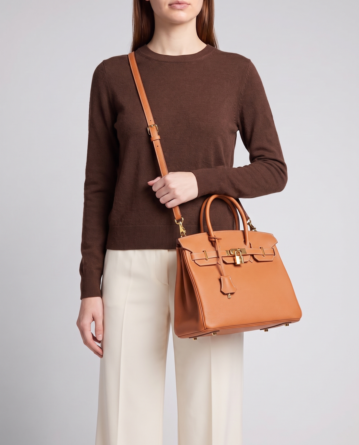Lock Small leather top-handle bag in Caramel – model wearing it crossbody on the detachable shoulder strap