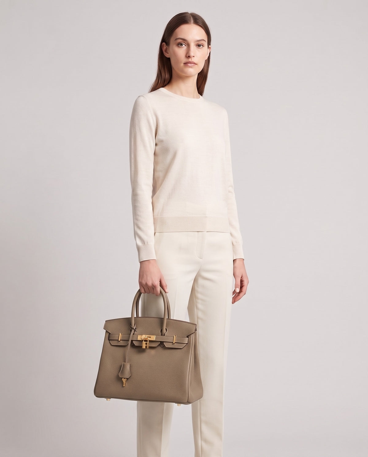 Lock Small leather top-handle bag in Taupe – model holding it, full length