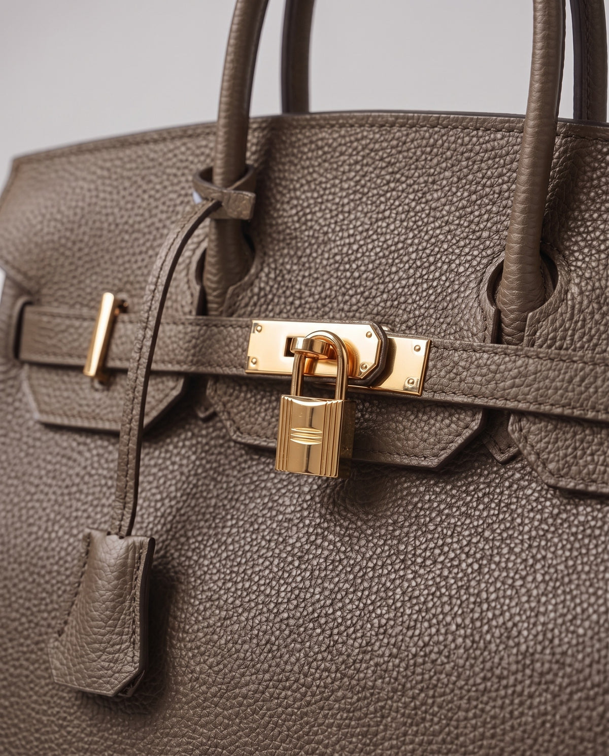 Lock Small leather top-handle bag in Taupe – close-up of the gold turn-lock and padlock