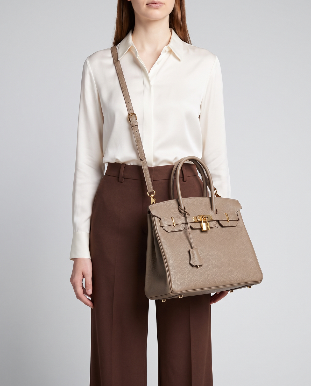Lock Small leather top-handle bag in Taupe – model wearing it crossbody on the detachable shoulder strap
