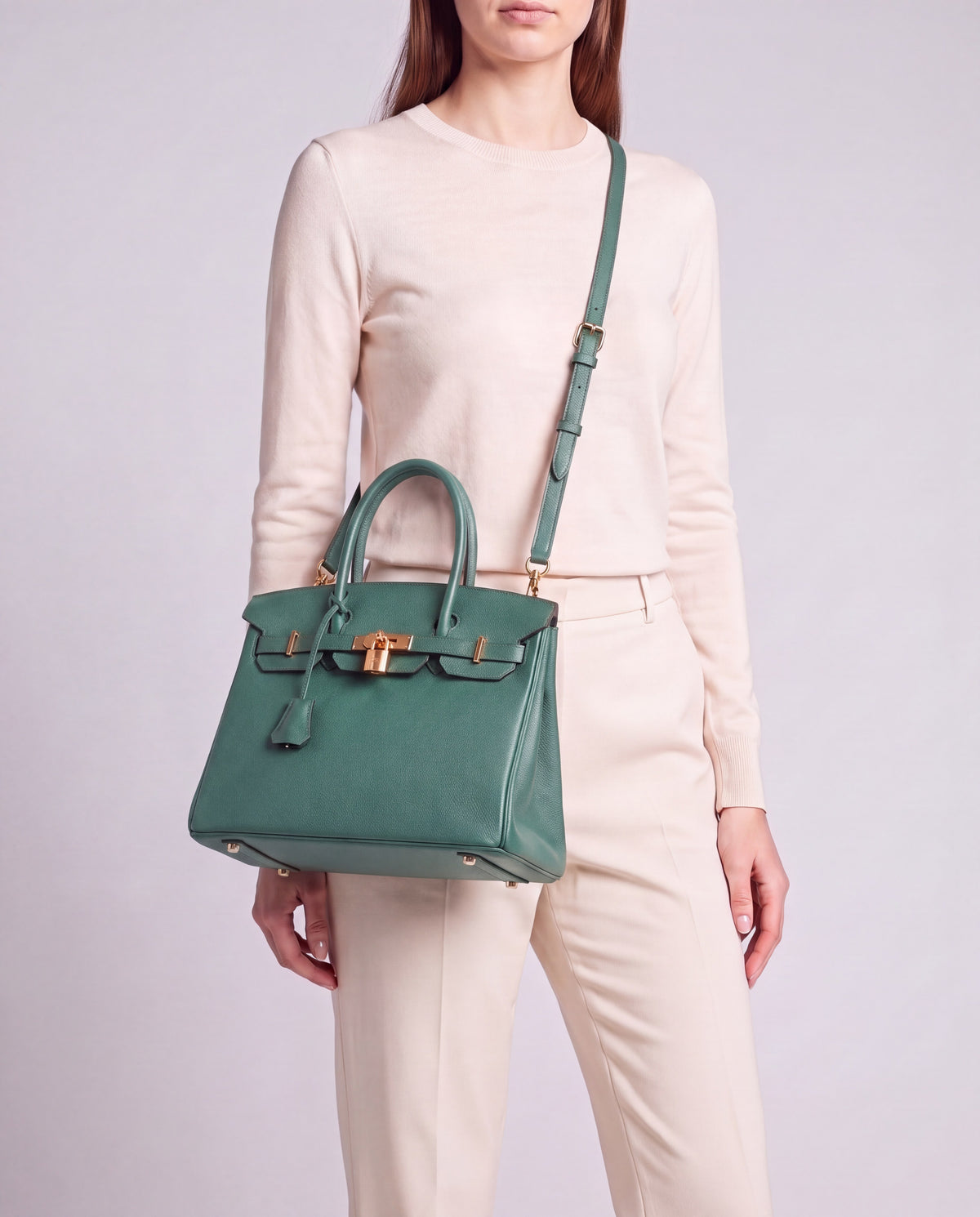 Lock Small leather top-handle bag in Velvet Green – model wearing it crossbody on the detachable shoulder strap