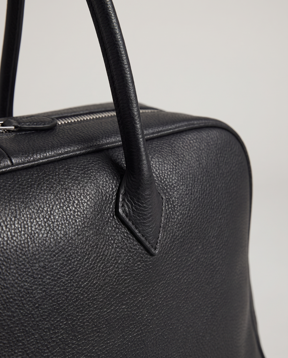 Ora Small leather shoulder bag in Black – close-up of the strap tab and pebbled leather