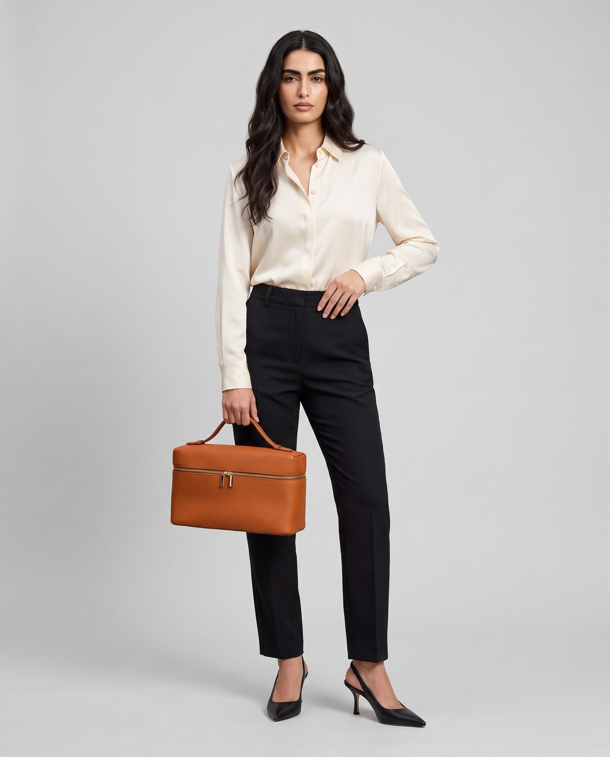 Model holding the Orvieto vanity case in Cognac – full-length view