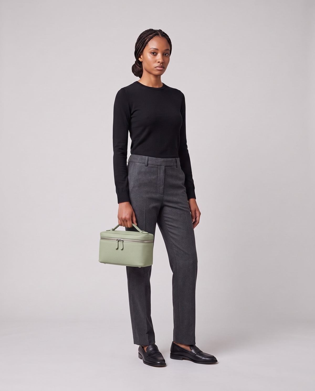 Model holding the Valentina Orvieto Small top-handle bag in Sage leather, full length