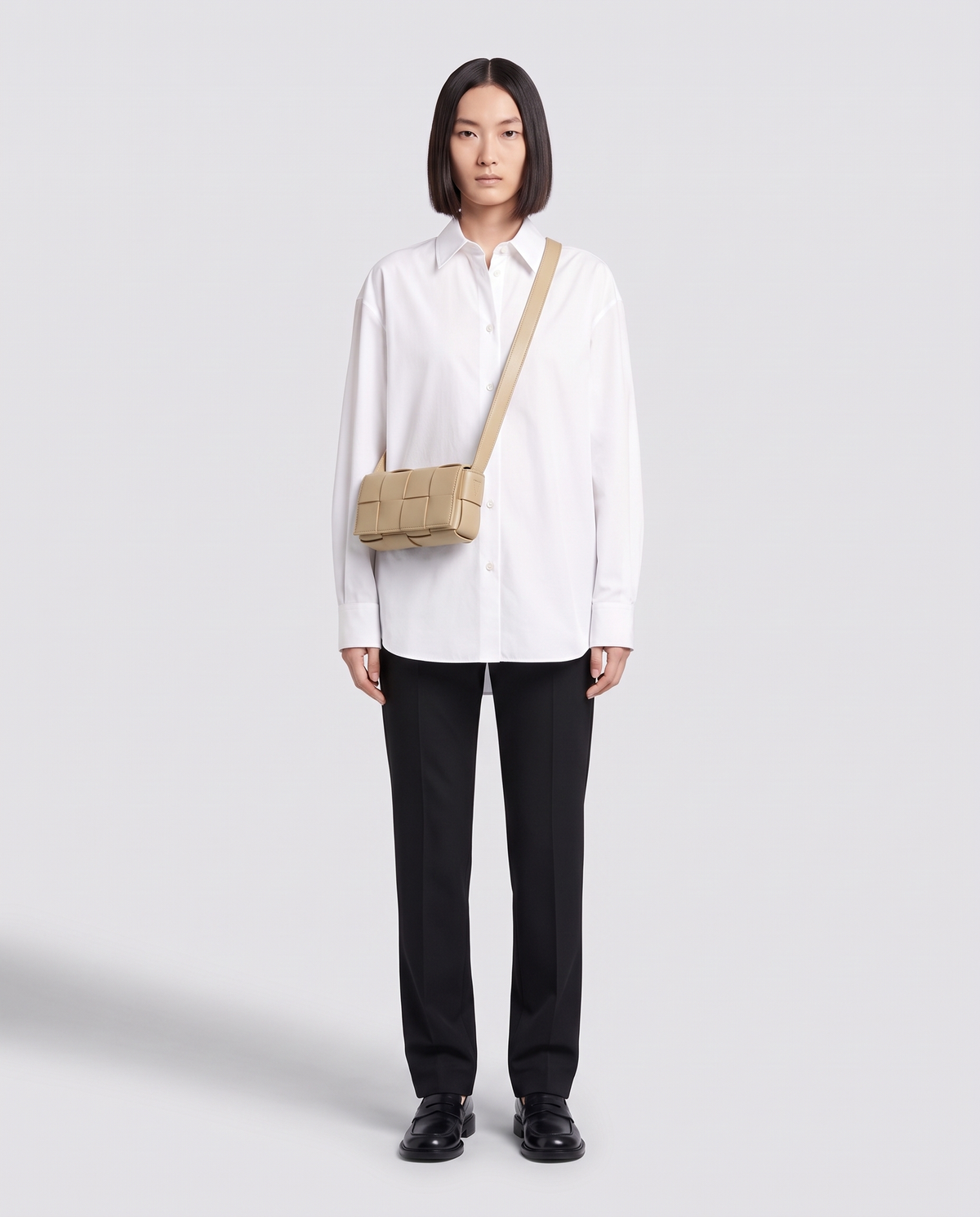 Cassette padded woven leather belt bag in Beige – model wearing it crossbody, full length