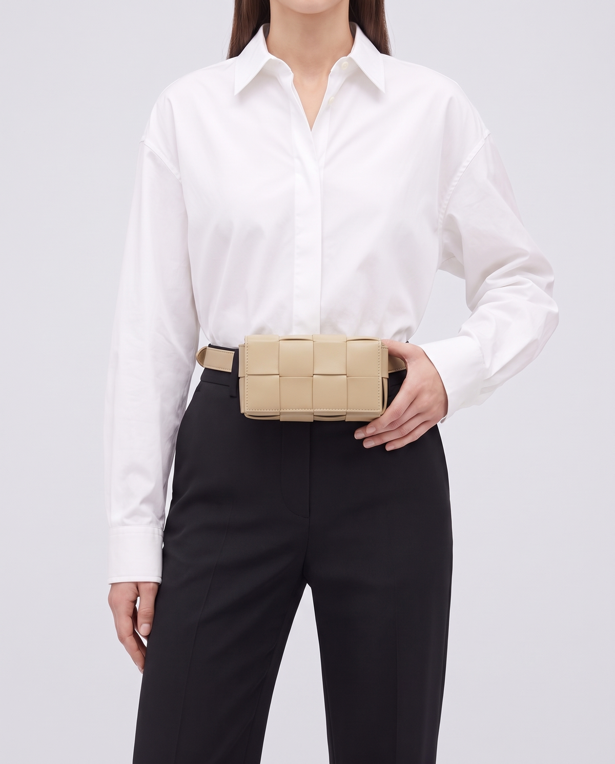 Cassette padded woven leather belt bag in Beige – model wearing it at the waist