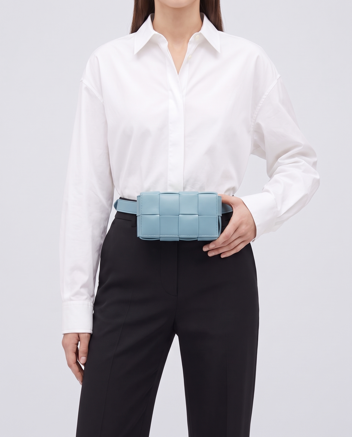 Cassette padded woven leather belt bag in Blue – model wearing it at the waist
