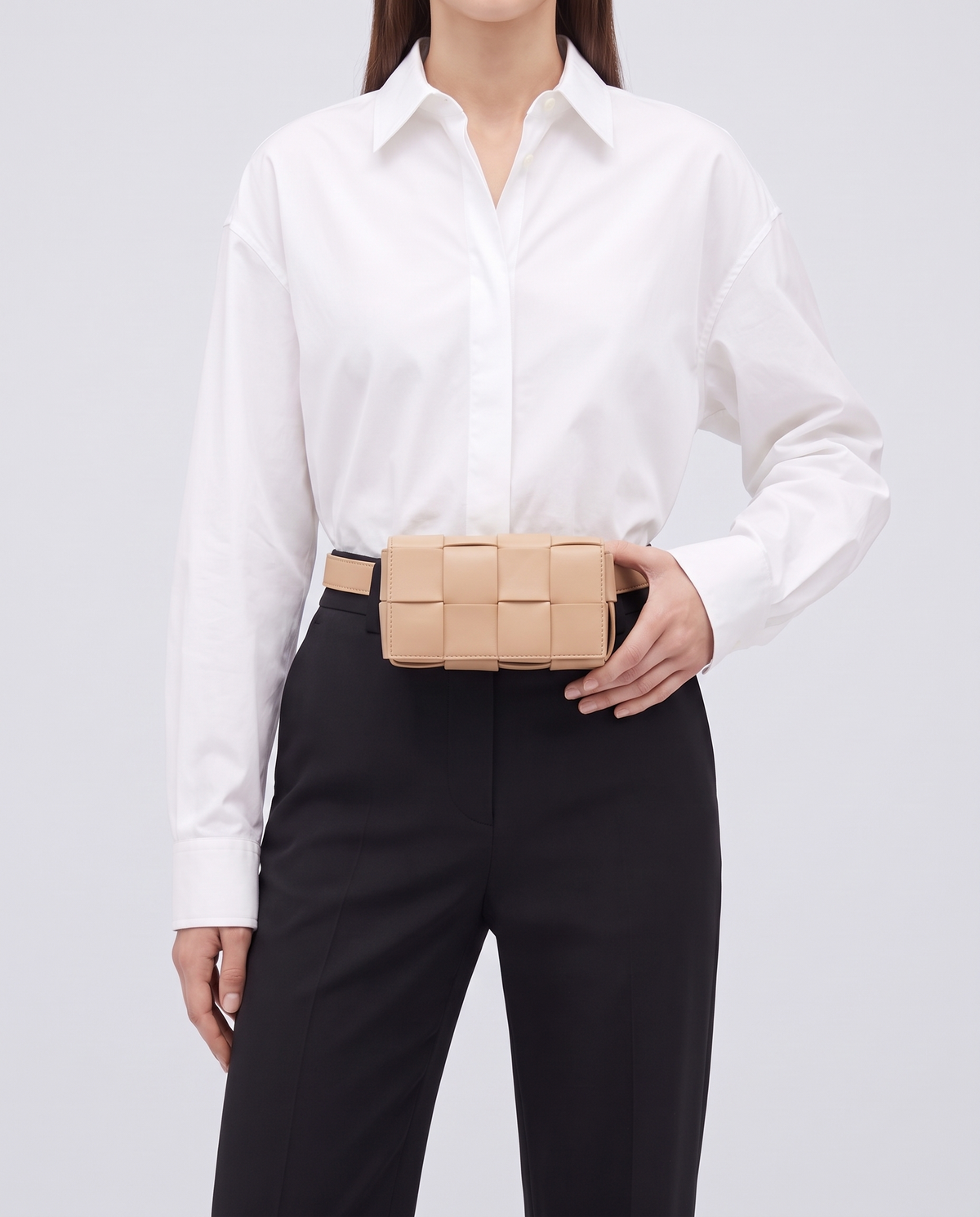 Cassette padded woven leather belt bag in Nude – model wearing it at the waist