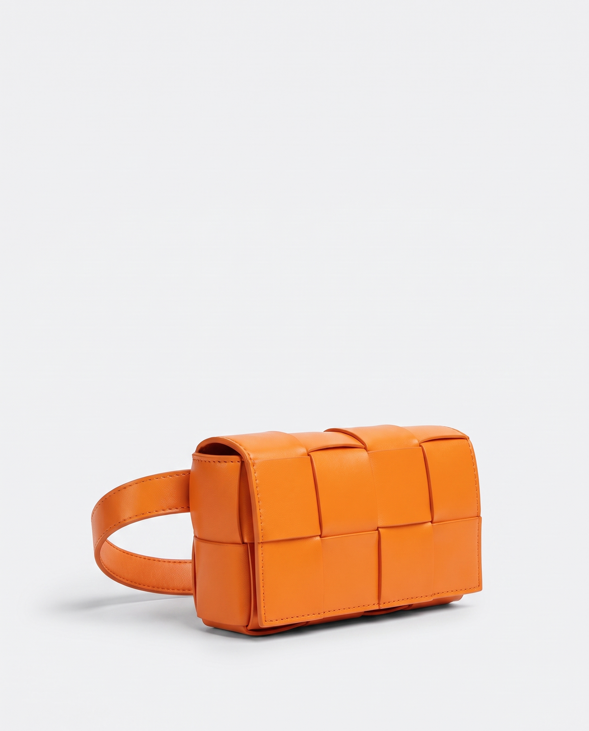Cassette padded woven leather belt bag in Orange – three-quarter view