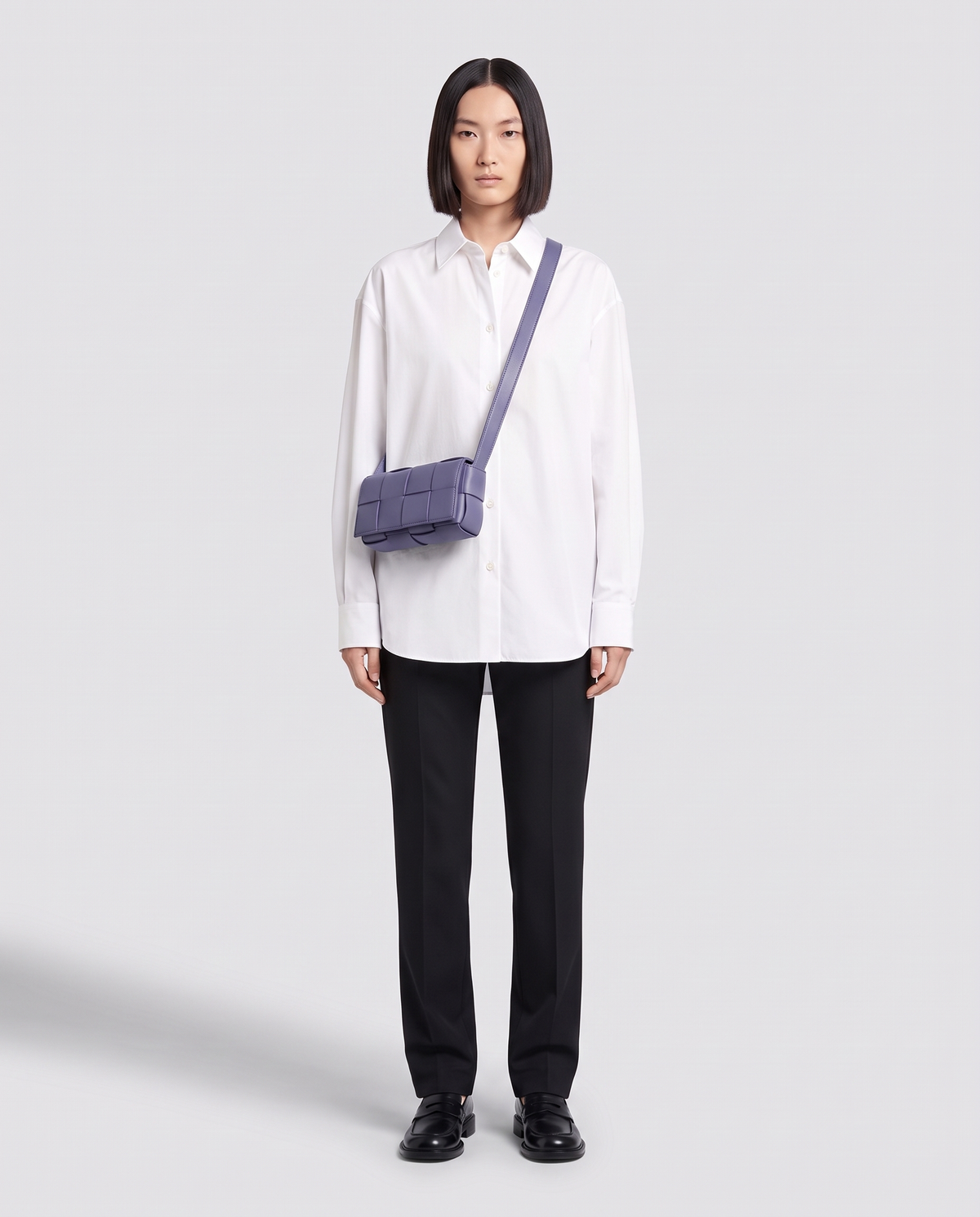 Cassette padded woven leather belt bag in Purple – model wearing it crossbody, full length