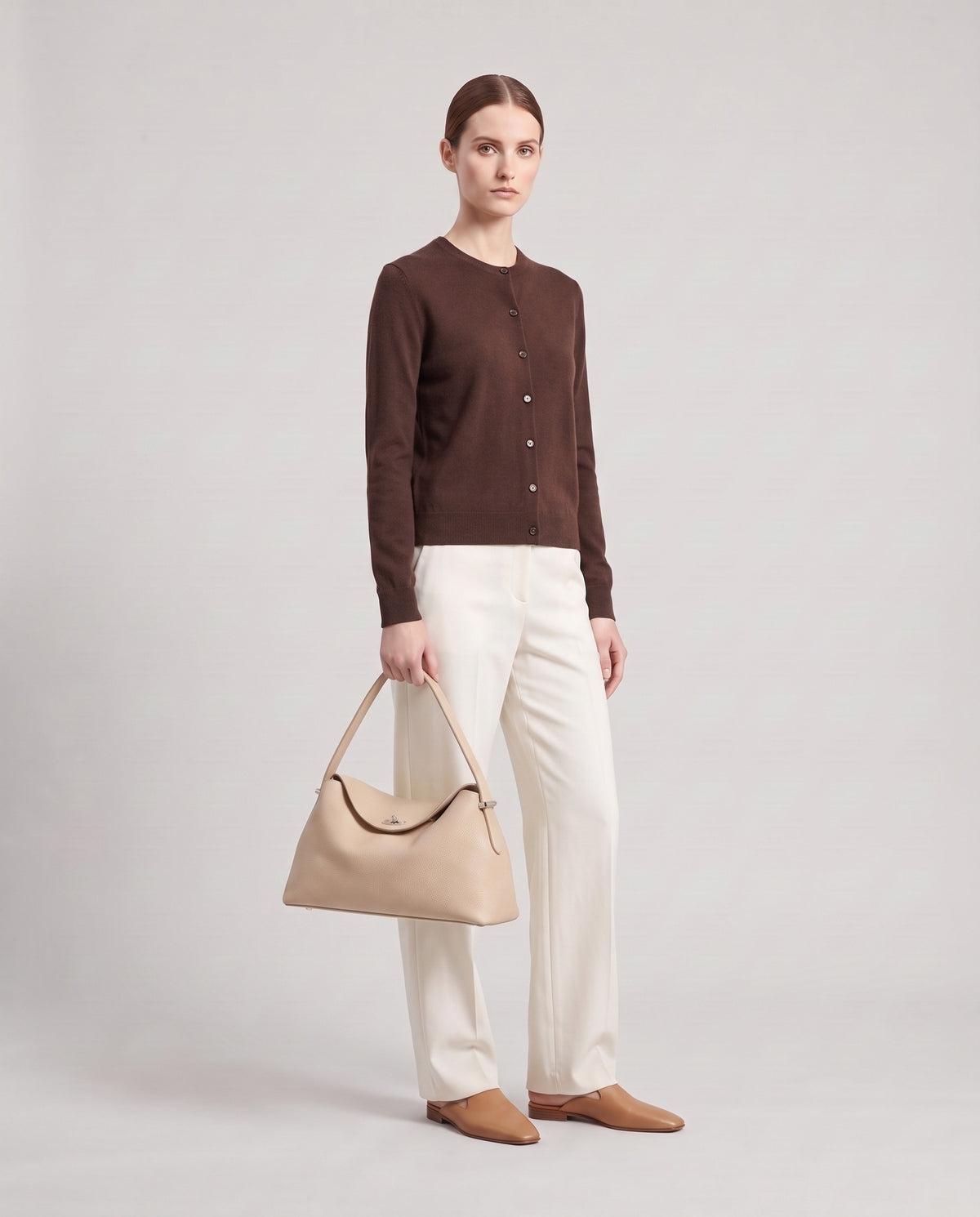 Model holding the Porto top-handle bag in beige, full length