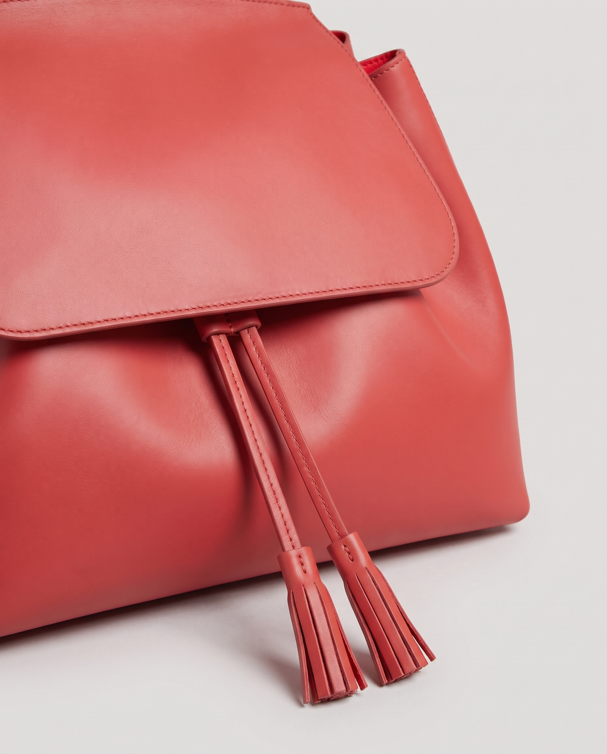 Roam Large leather backpack in Red – close-up of the drawstring tassels and flap