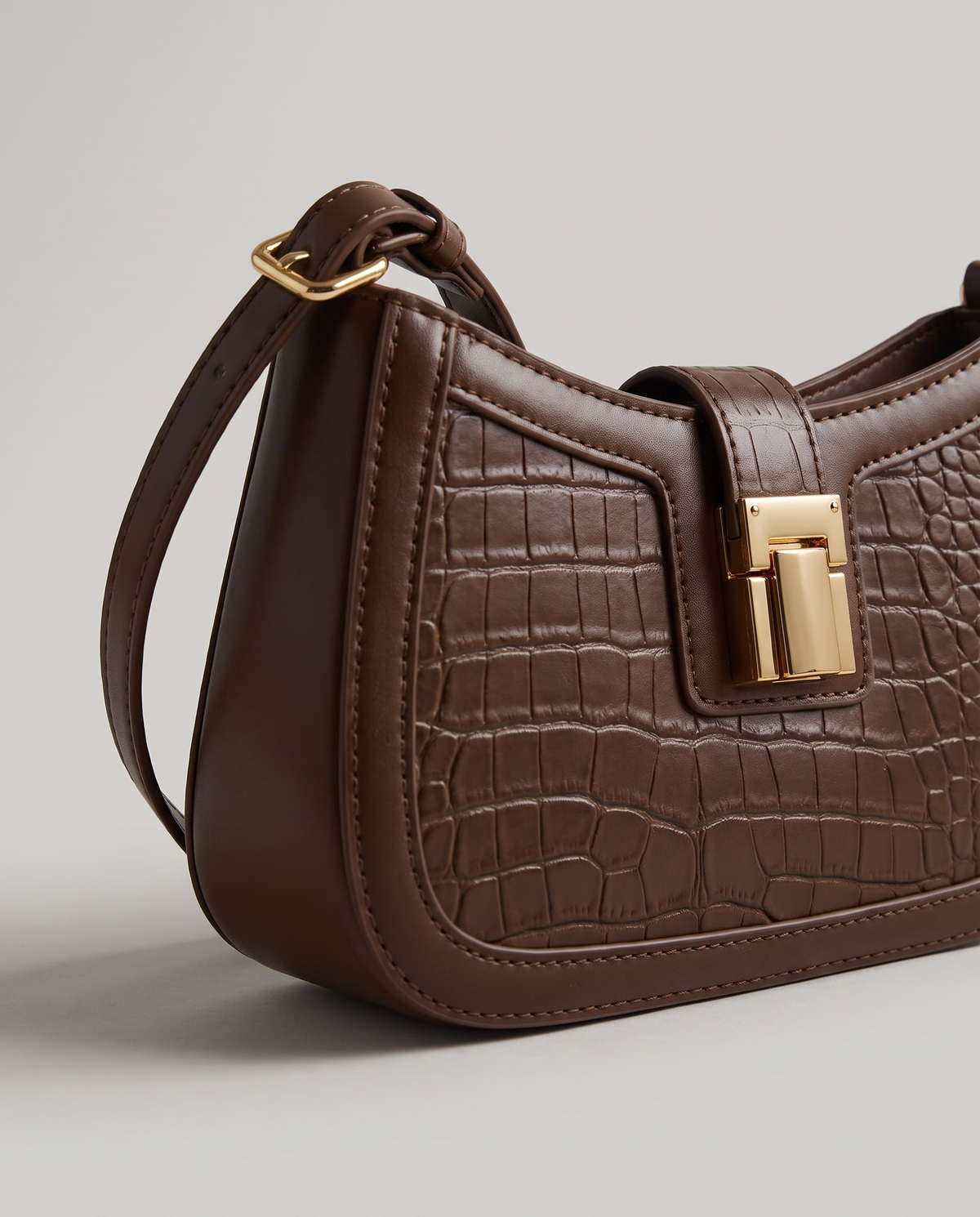 Sable croc-embossed shoulder bag in Brown – close-up of the gold push-lock clasp