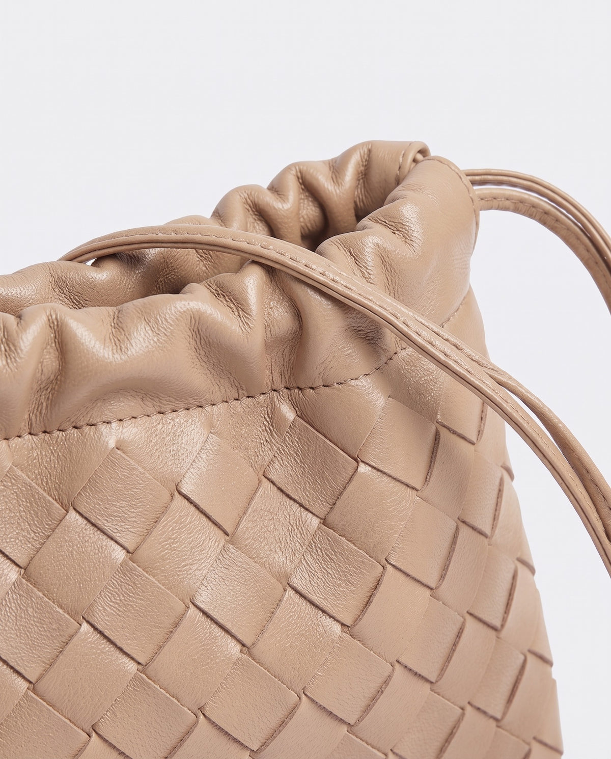 Serata woven leather clutch in Beige – drawstring detail