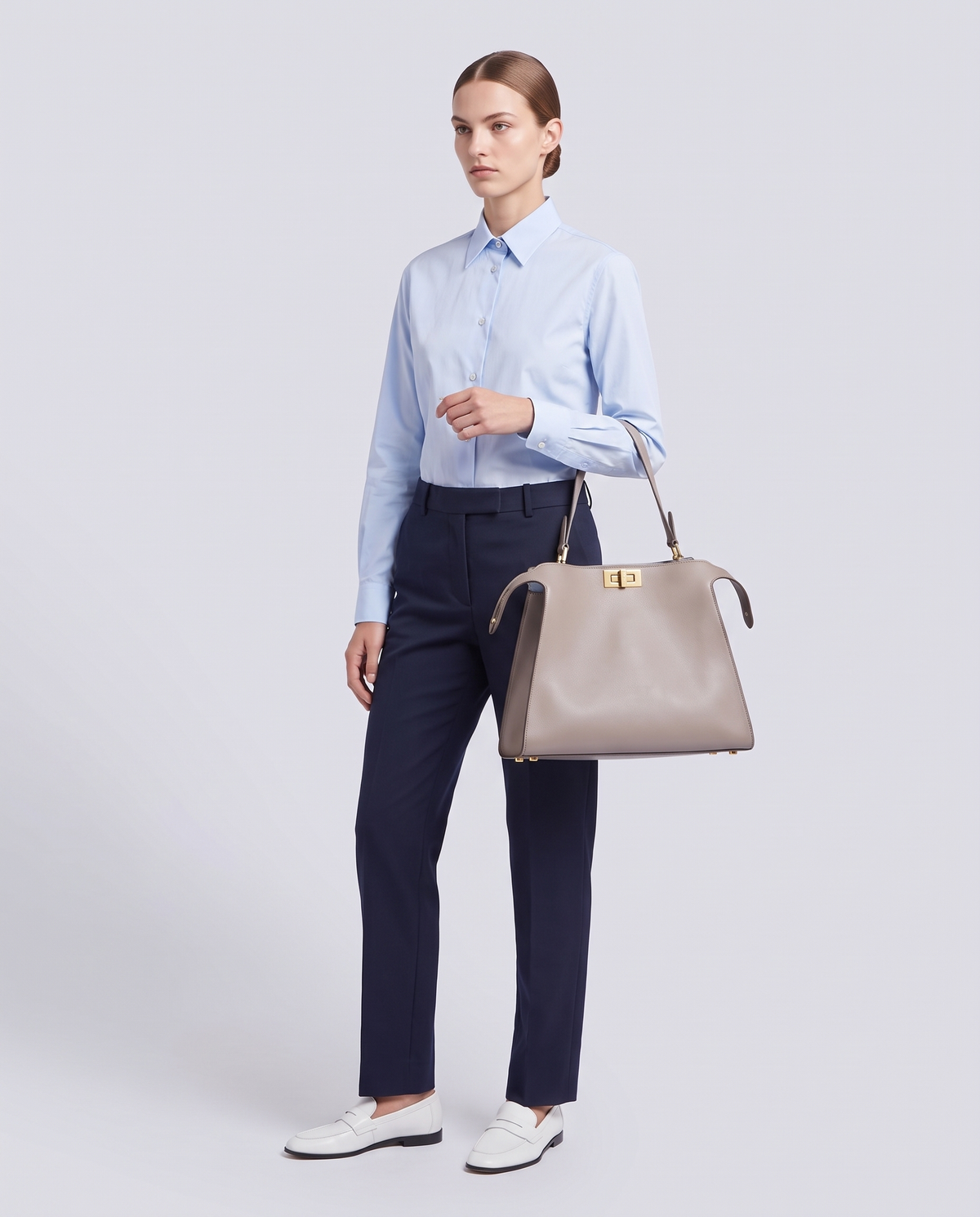 Model carrying the Siracusa leather bag in Stone – full length