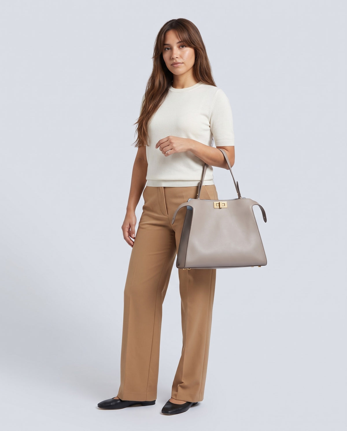 Model carrying the Siracusa leather bag in Stone – full length