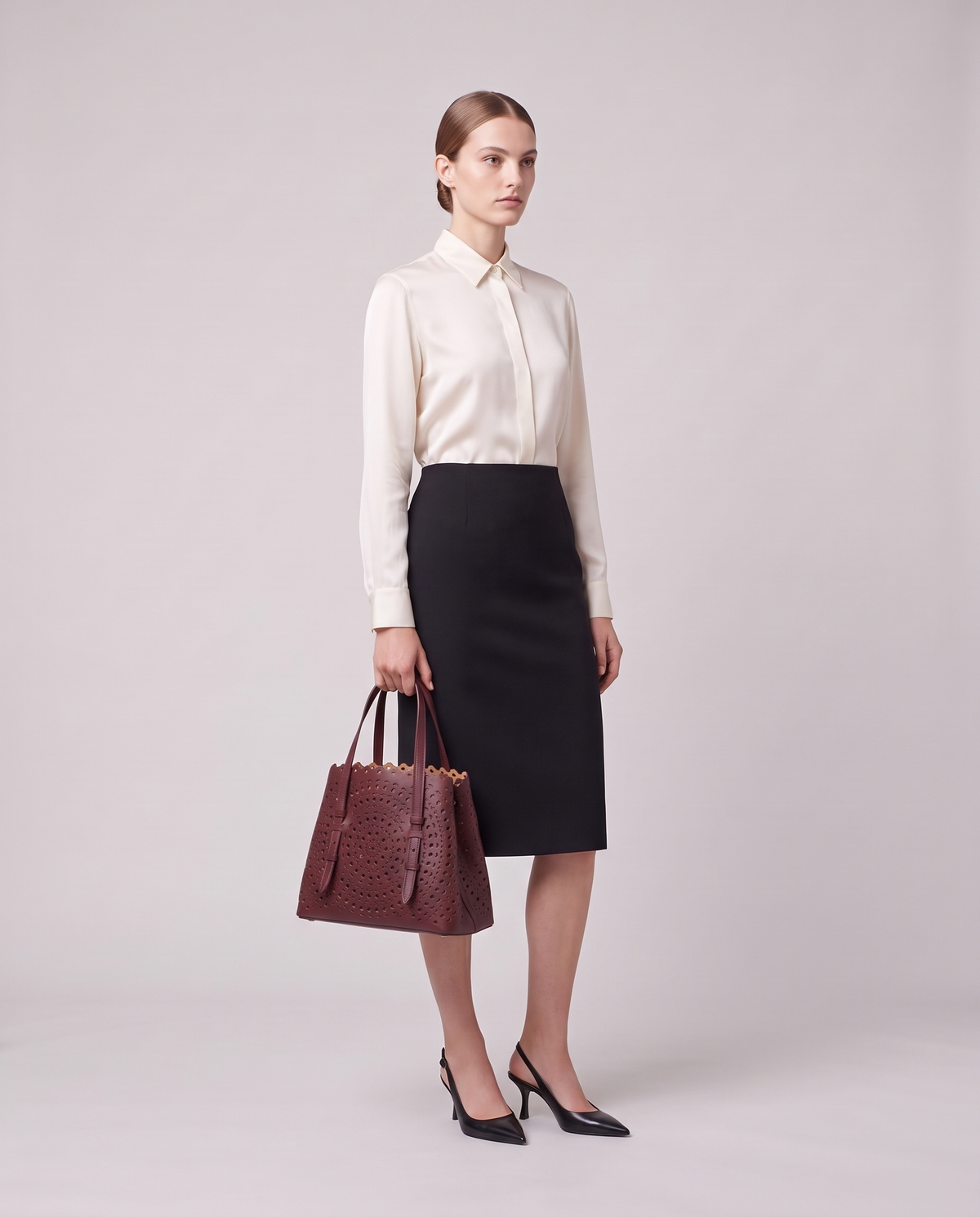 Model holding the Valentina Urbino Large bag in Burgundy, full length