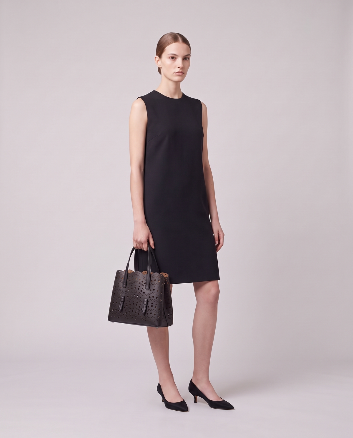 Model holding the Valentina Urbino Medium bag in Black, full length